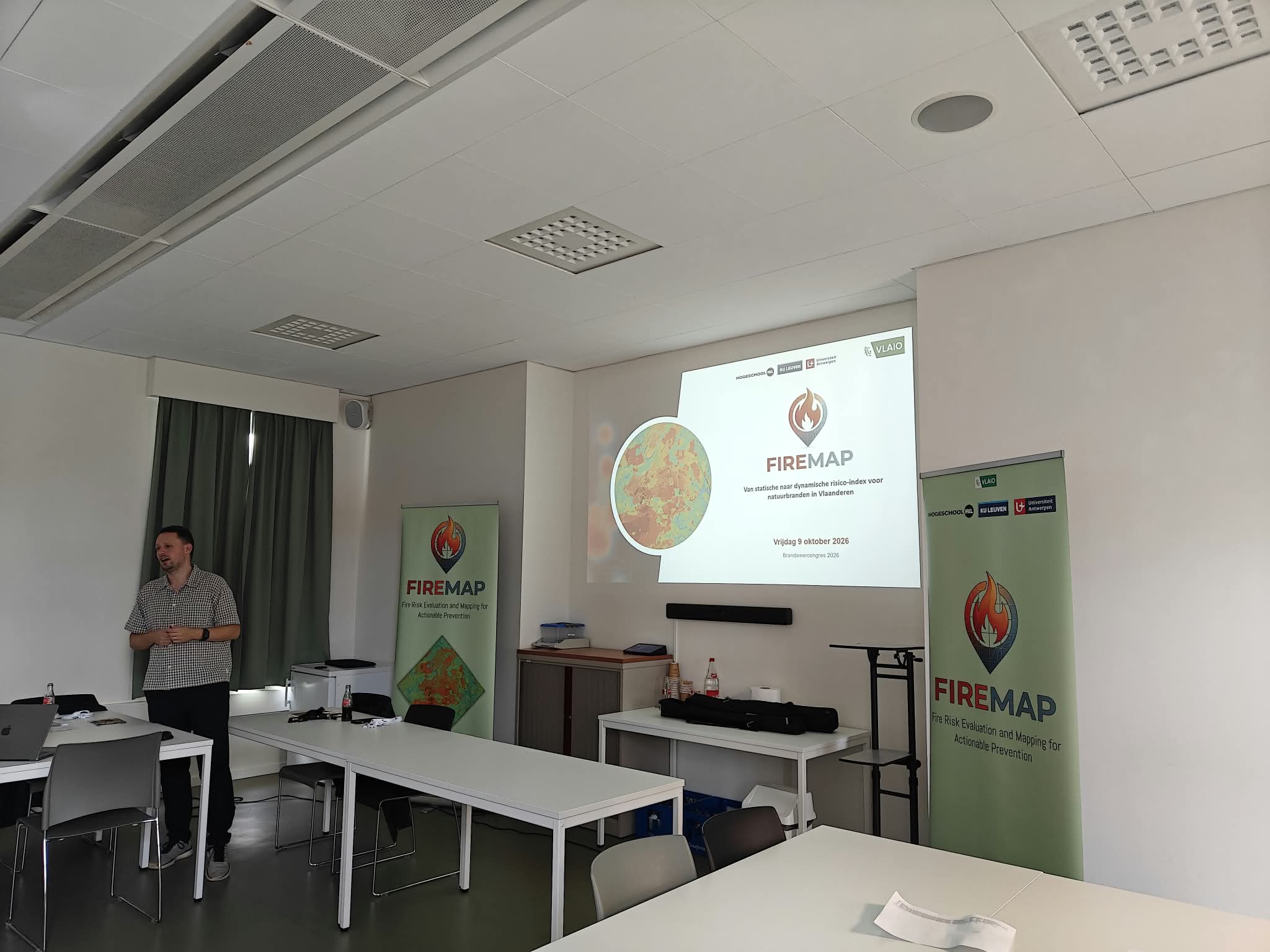 Een spreker presenteert FireMap naast de titelslide over de dynamische risico-index voor natuurbranden